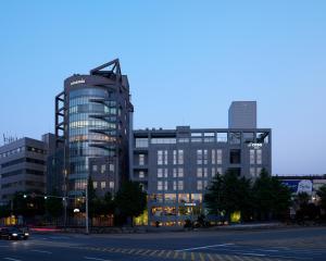 a large glass building in a city at night at La Casa Hotel Seoul in Seoul