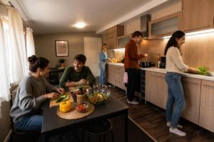 a group of people in a kitchen preparing food at Hang The Hat in Valmiera