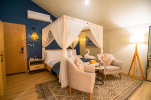 a bedroom with a canopy bed and a table and chairs at Khoj Resorts Shigar in Shigar