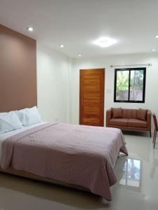 a bedroom with a large bed and a couch at Residencia de Azucena in Tacloban