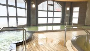 a bath room with a hot tub at 昆布川温泉幽泉閣 in Rankoshi