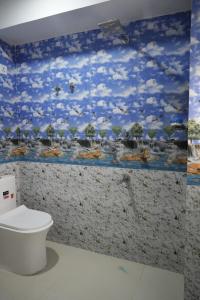 a bathroom with a toilet and a painting on the wall at Retreat Homes in Siliguri