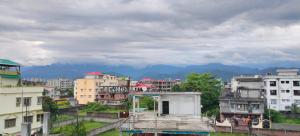 a group of buildings in a city with mountains at Retreat Homes in Siliguri