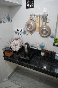 a kitchen counter with a sink and utensils at Retreat Homes in Siliguri +9 photos
