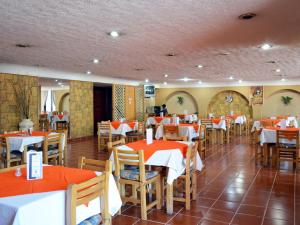 a restaurant with tables and chairs with red tablecloths at Hotel Santa Cruz in Mexico City