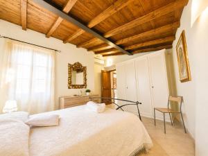 a bedroom with a white bed with a wooden ceiling at Sant'Ippolito in Asciano +20 photos