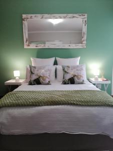 a bedroom with a large bed with a green wall at 47atKabega in Gqeberha