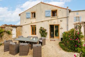 an external view of a house with a table and chairs at Opaline à la Rochelle in Vergné