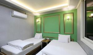 two beds in a room with green walls at Gukmin Hotel in Gumi +35 photos