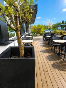 a wooden deck with tables and chairs and a tree at Best Western Eskilstuna Arena Hotel in Eskilstuna