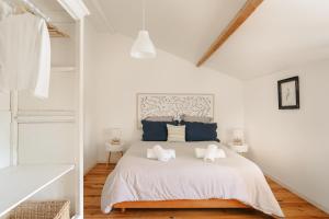 a white bedroom with a bed with two pillows at Opaline à la Rochelle in Vergné +18 photos