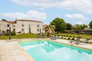 a villa with a swimming pool in front of a house at Opaline à la Rochelle in Vergné