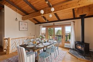 a dining room with a table and chairs and a fireplace at Velvet Timber Haus | HotTub, Sauna, Firepit, Games in Windham