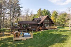 a large wooden house with a large yard at Velvet Timber Haus | HotTub, Sauna, Firepit, Games in Windham