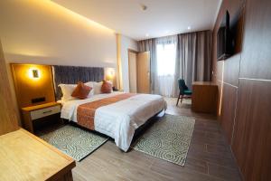 ein Hotelzimmer mit Bett und Fernseher in der Unterkunft Barkat hôtel in Baraki