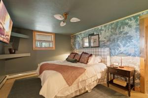 a bedroom with a bed and a painting on the wall at Velvet Timber Haus | HotTub, Sauna, Firepit, Games in Windham