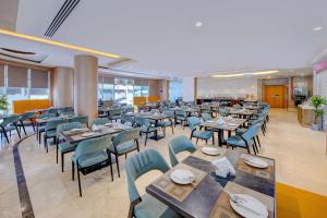 a dining room with tables and chairs and a cafeteria at Best Western Premier M Four Hotel in Dubai