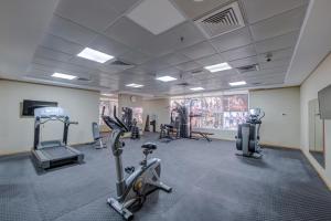 a gym with several treadmills and machines in a room at Best Western Premier M Four Hotel in Dubai