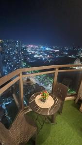 a table and chairs on a balcony at night at Suite City view in Manila