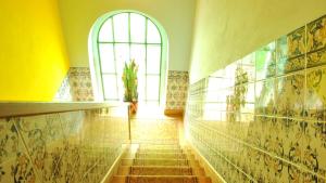 a hallway with a window and stairs in a building at Hospedaria Pielas in Sintra