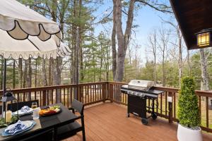 a screened in deck with a grill and a picnic table at Velvet Timber Haus | HotTub, Sauna, Firepit, Games in Windham