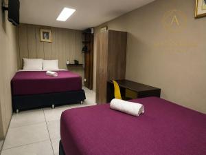 a hotel room with two beds with purple sheets at Hotel Alcántara Boutique in San Salvador +21 photos
