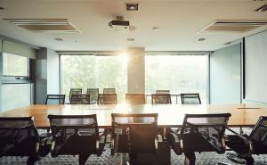 a conference room with a large wooden table and chairs at La Casa Hotel Seoul in Seoul