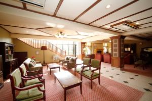 a living room with chairs and tables and a staircase at Gora Hotel Paipuno Kemuri Plus in Hakone