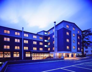 a large building with many windows in a parking lot at Gora Hotel Paipuno Kemuri Plus in Hakone