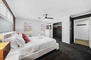 a white bedroom with a large bed and a window at Garrison Cottage in The Vines