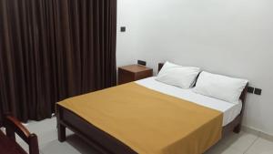 a bedroom with a bed with brown drapes at Devi Royal Residency in Mararikulam