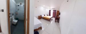 a bathroom with a bed and a toilet in a room at Devi Royal Residency in Mararikulam