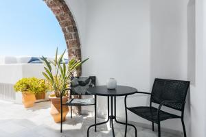 a table and chairs on a patio with plants at Mirabo Villas in Firostefani