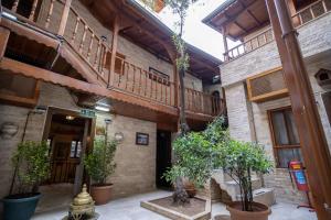 a building with a staircase and potted trees in a courtyard at Zeynep Hanim Konagi in Gaziantep