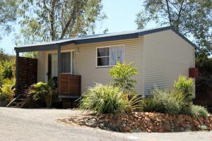 a tiny house in a yard with plants at Silver Wattle Cabins in Mount Morgan