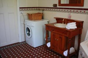 een badkamer met een wasmachine en een wastafel bij Greenock's Old Telegraph Station in Greenock