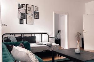 a living room with a green couch and a table at City Retreat Zwickau mit Balkon zum Innenhof in Zwickau