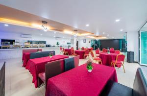 a dining room with red tables and chairs at The Kris Resort Hotel in Patong Beach