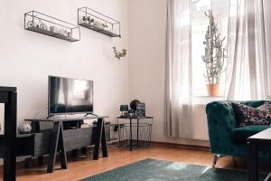 a living room with a television and a green couch at City Retreat Zwickau mit Balkon zum Innenhof in Zwickau