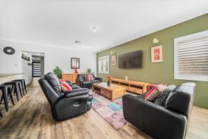 a living room with two couches and a tv at Garrison Cottage in The Vines