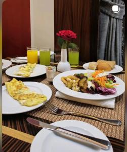 a table with plates of food and drinks on it at Hotel Grand Kings Premium in New Delhi