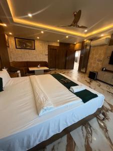 a large white bed in a room with a table at Hotel V Square in Lucknow