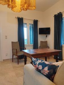 a dining room with a wooden table and chairs at Alexandria Aegean View in Gavrio