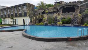 una grande piscina di fronte a un edificio di Angkasa Garden Hotel a Pekanbaru