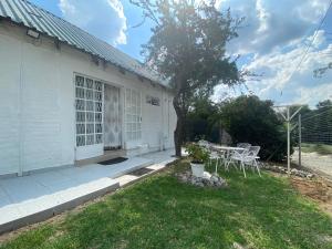 a white house with a table and chairs in the yard at Fiet Star in Midrand