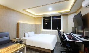 a hotel room with a bed and a desk with a computer at Gukmin Hotel in Gumi