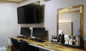 a desk with two computer monitors and a mirror at Gukmin Hotel in Gumi