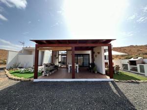 a house with a patio with a roof at Private villa with pool in the mountains in Pájara