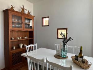 a dining room with a white table and white chairs at Private villa with pool in the mountains in Pájara