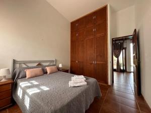 a bedroom with a bed with a dresser and a mirror at Private villa with pool in the mountains in Pájara